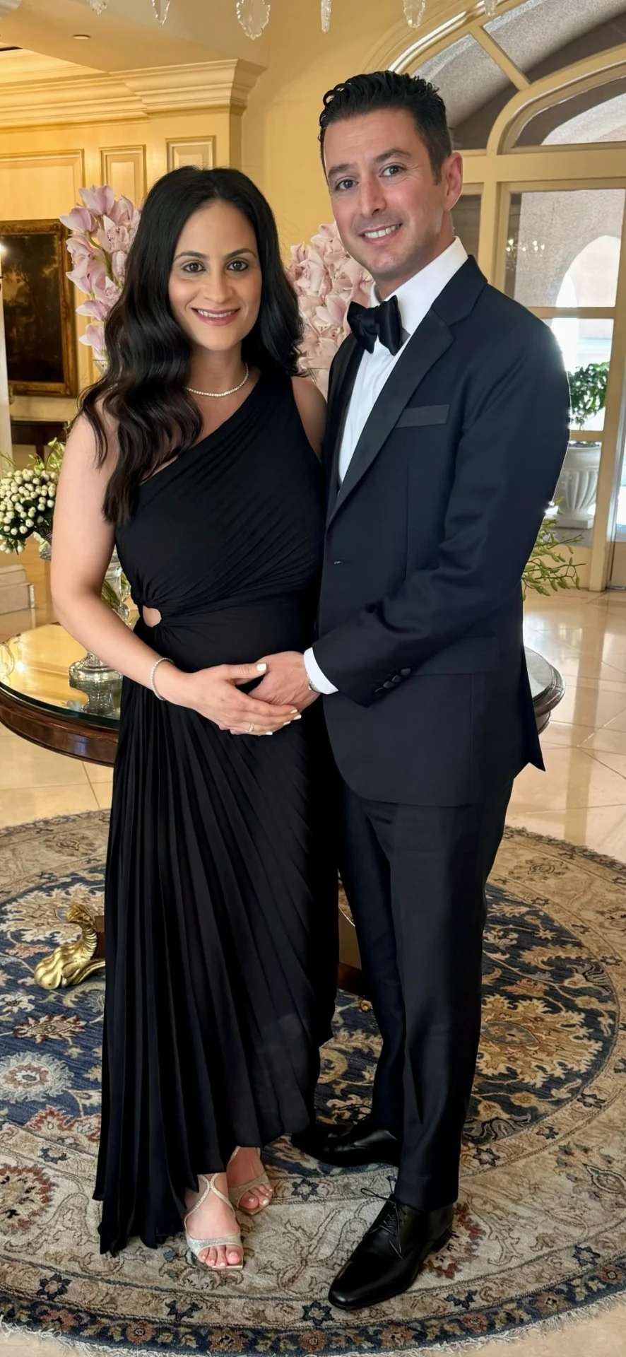 A man and woman in formal wear posing for the camera.