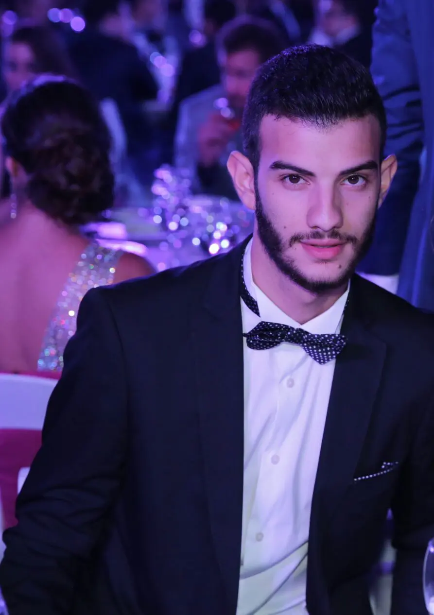 A man in a suit and bow tie at an event.