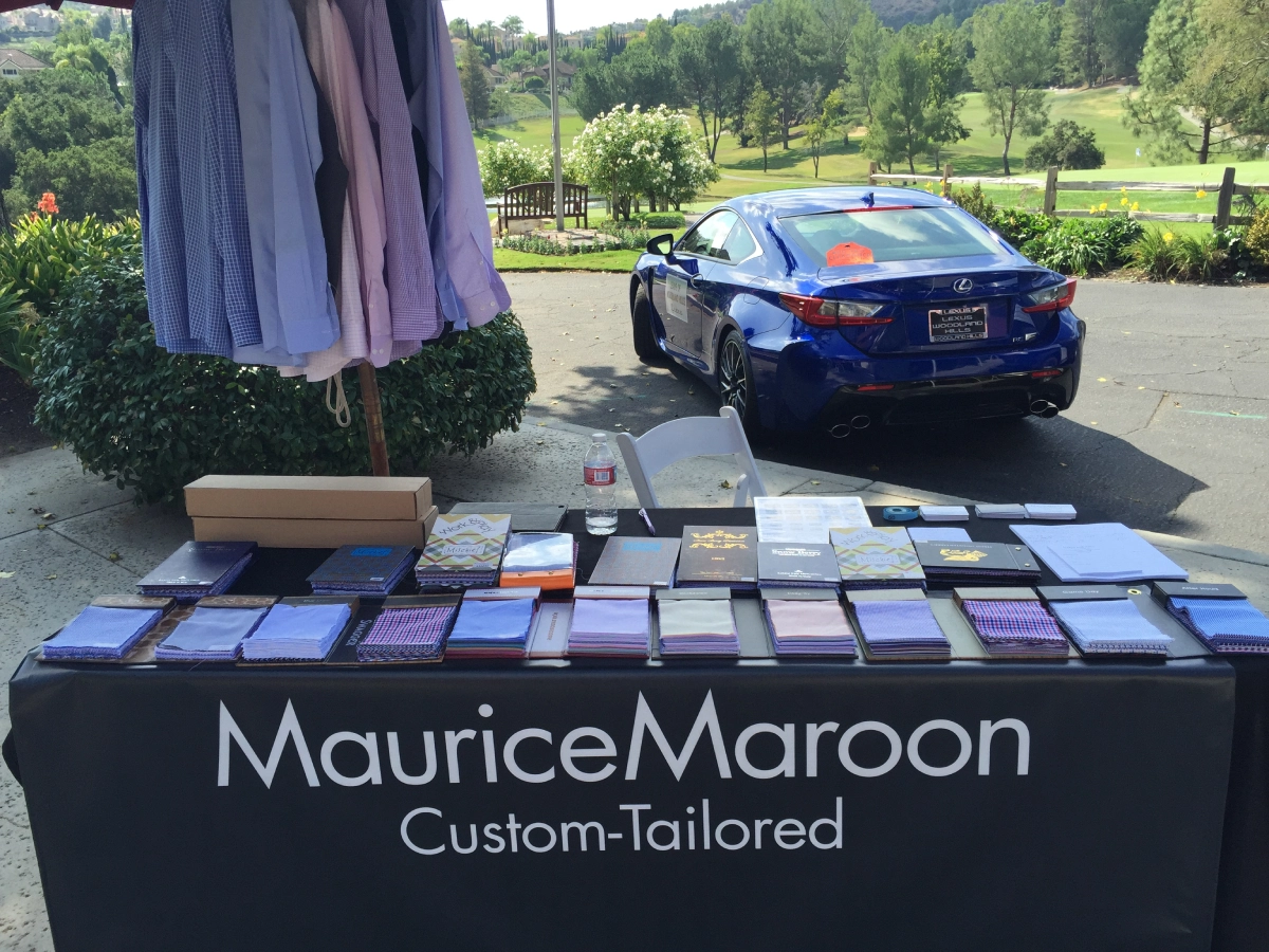 A table with purple clothes and a car in the background.