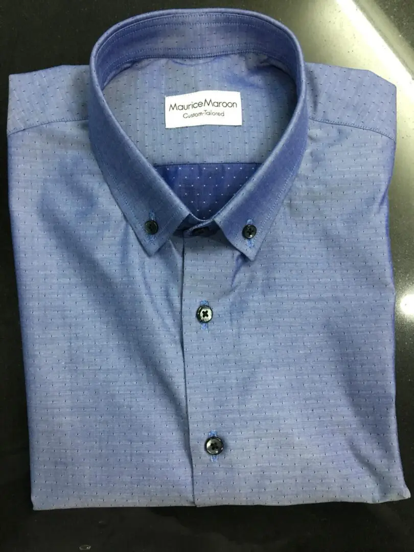 A blue shirt with a button down collar and a patterned design.